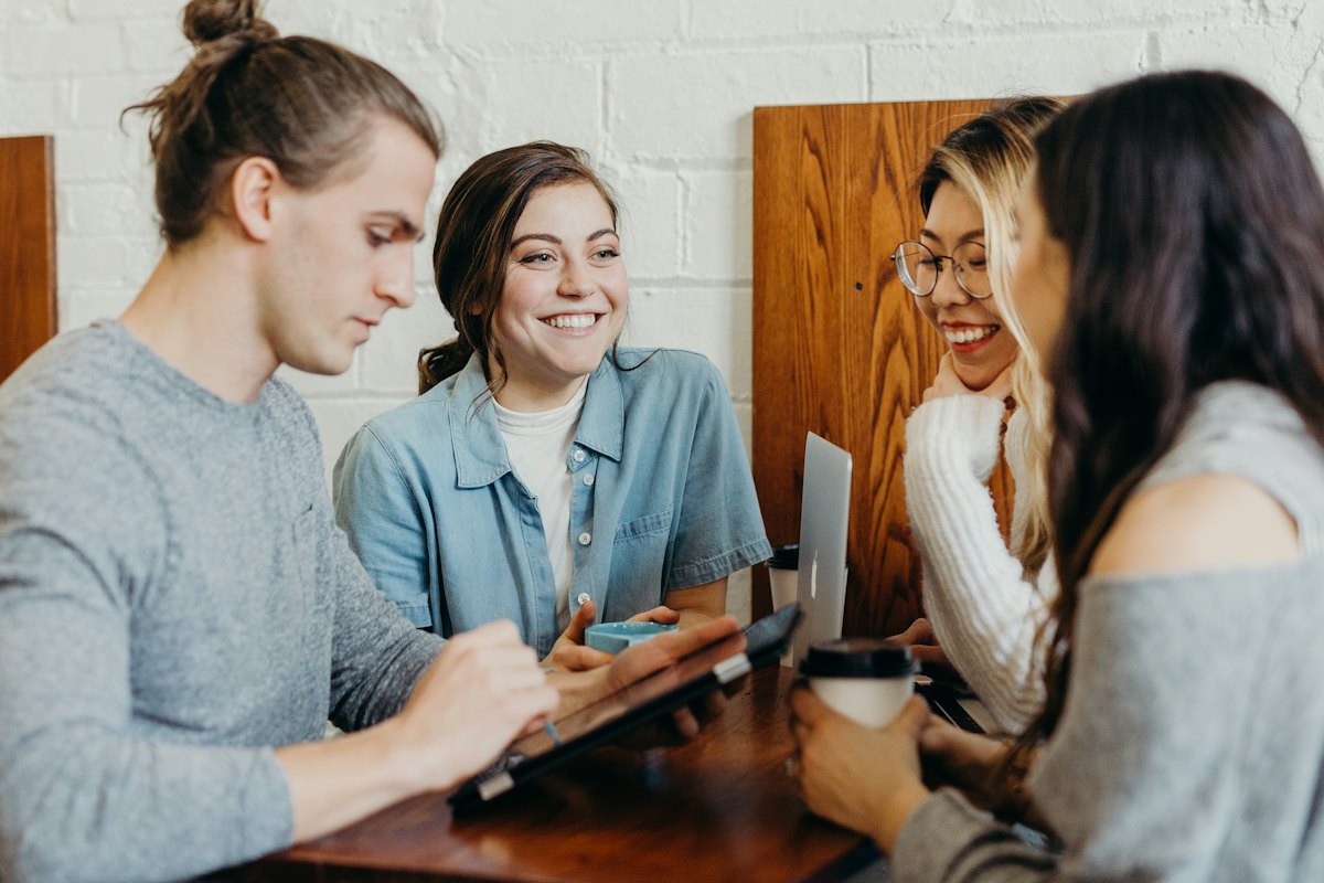 Amigos conversando e rindo em volta de uma mesa